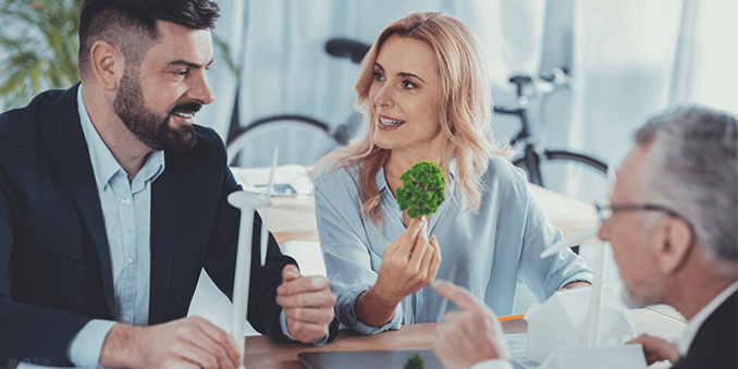 Drei Geschäftsmenschen besprechen in einem Meeting ein Modell zu erneuerbaren Energien