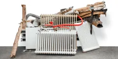Gebäudemodernisierungsgesetz: nicht mehr gebrauchte Heizkörper liegen in einem Zimmereck