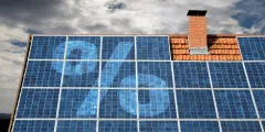 Photovoltaikanlage auf einem Hausdach mit groß dargestelltem Prozentzeichen auf den Solarmodulen als Symbol für Einspeisevergütung, Förderungen und Wirtschaftlichkeit von PV-Anlagen.